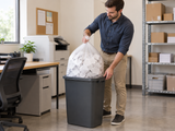 Garbage Bags - 30" x 38" - Clear - X-Strong - 20-30 gal - 125/Case closed clear bag being removed from an opaque commercial waste bin in an office workroom