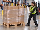 Clear hand stretch wrap being applied to a palletized load from the opposite side