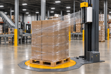 Machine stretch wrap feeding from an elevated carriage around a palletized load
