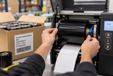 Wax thermal transfer ribbon being installed in a warehouse label printer