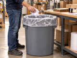 Garbage Bags - 42" x 48" - Clear - X-Strong - 50-55 gal - 75/Case fitted in an opaque commercial waste bin at a warehouse packing station