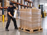 Clear hand stretch wrap securing a palletized load in a warehouse