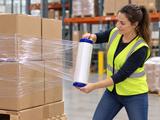 Stretch wrap hand saver dispensers in use wrapping a palletized load